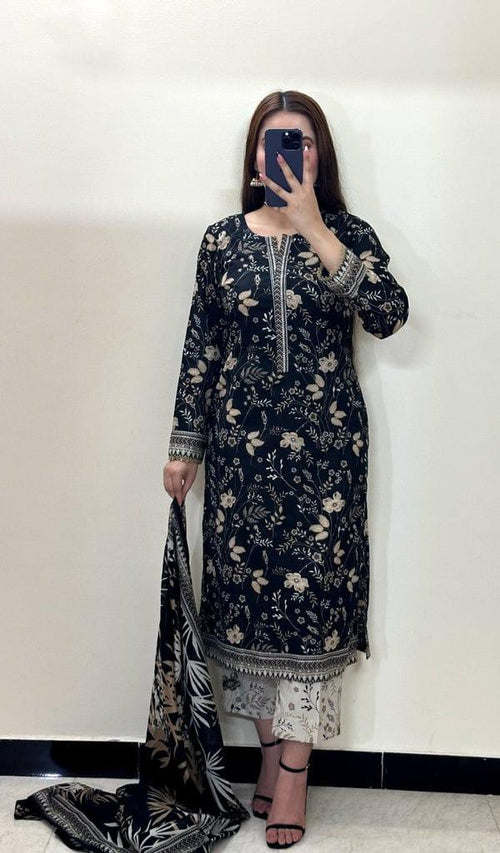 Woman in black floral printed kurta and white trousers holding matching dupatta