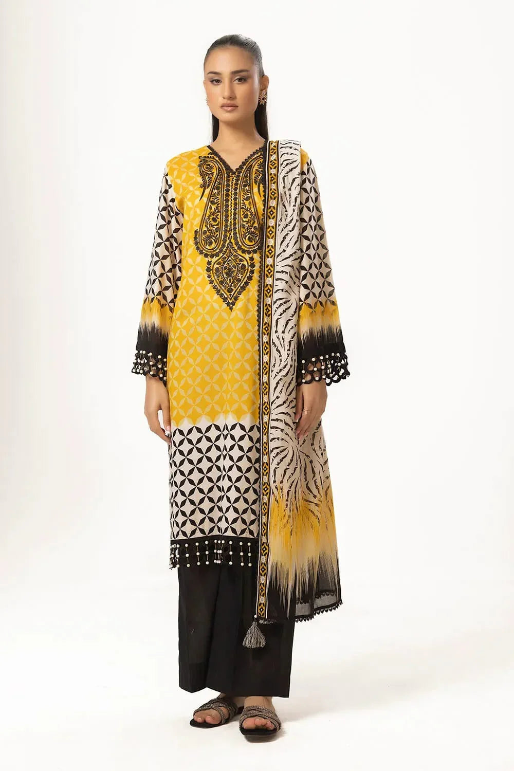 Woman wearing yellow and black geometric print long kurta with intricate neckline embroidery, matching dupatta, and black pants.